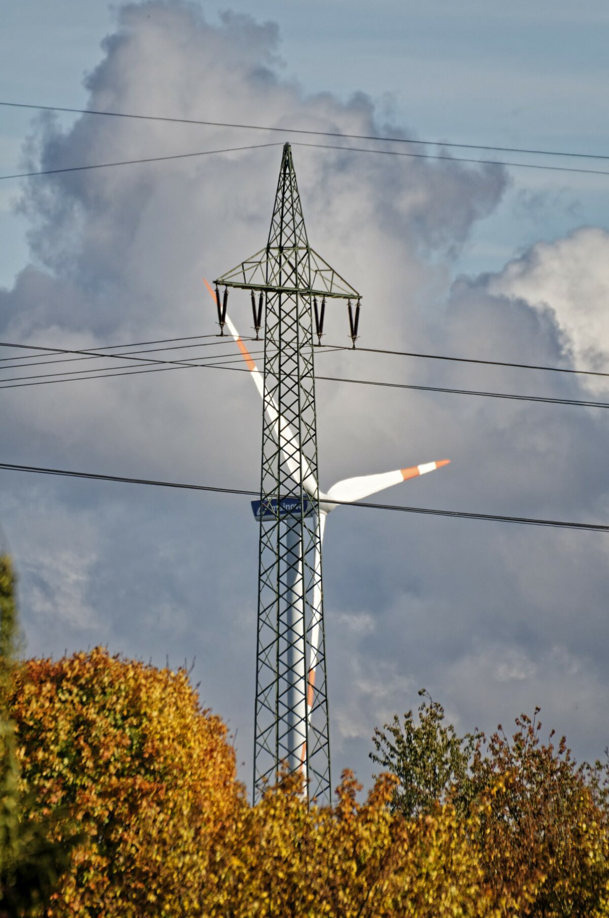 Windkraftanlage und Hochspannungsmast